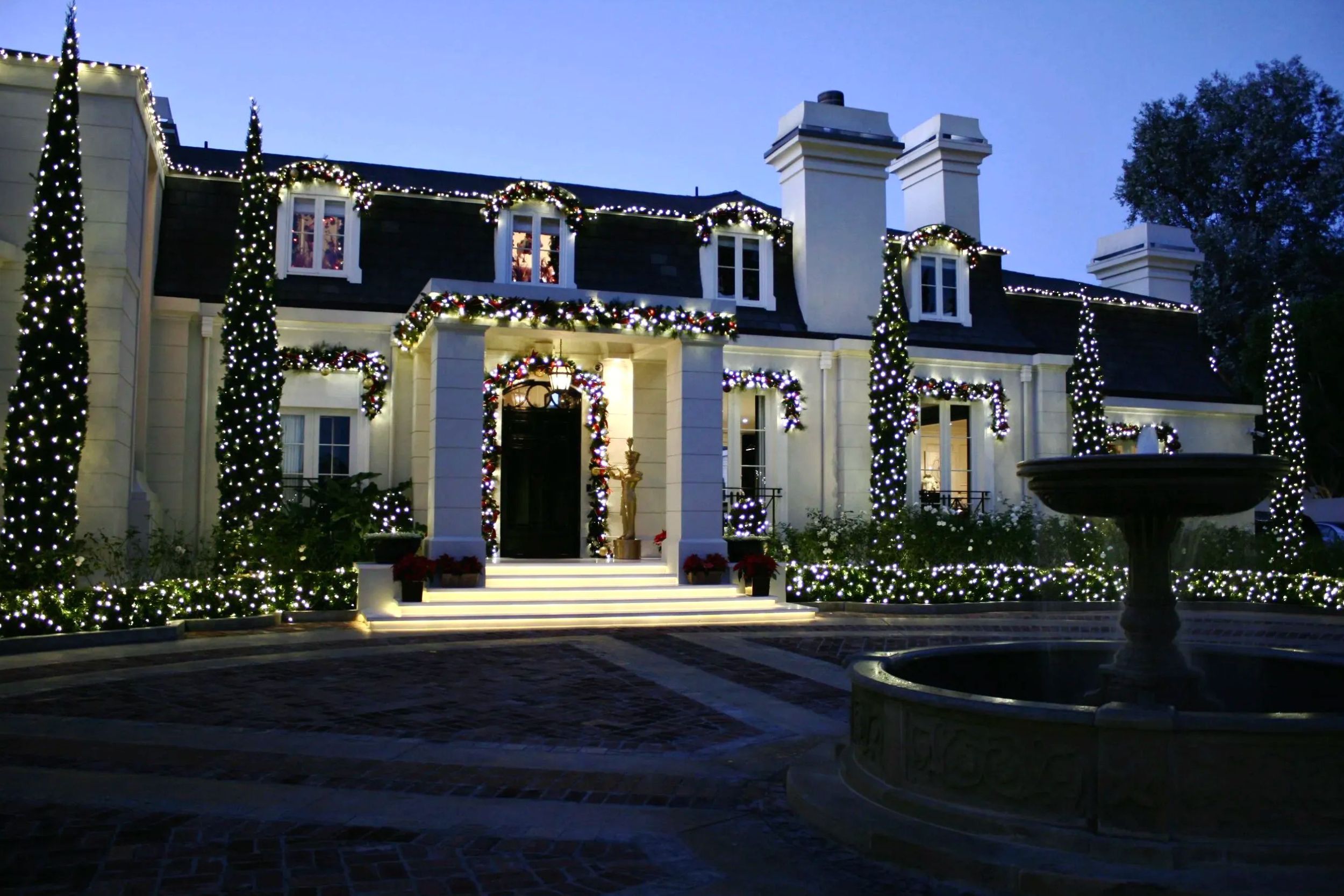 A home exterior wrapped in holiday lights and garland